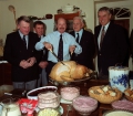 Harbourmasters and lifeboat coxswain Peter Bisson make sure that photographer Brian Green carves the turkey for Georgina Keene\'s christmas party - 1991